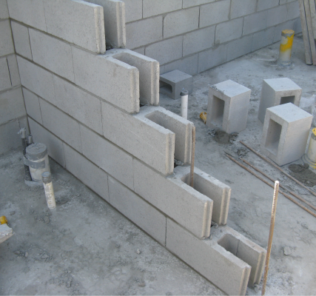 Perp_free_grey_block_wall_half_built_with_starter_bars_and_pipes_showing