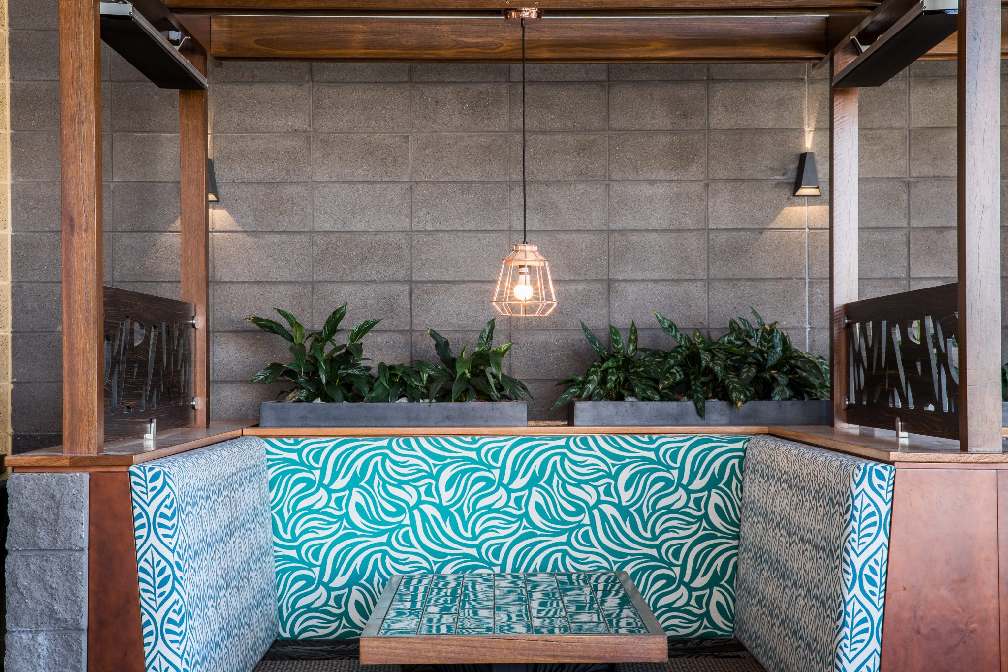 Modern_architectural_restaurant_featuring_smooth_charcoal_coloured_blockwork_with_timber_highlights_and_punches_of_colour_in_the_table_seating_and_surrounding_greenery