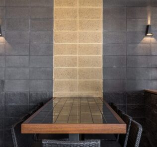 Table_setting_at_a_restaurant_with_a_polished_sandstone_feature_strip_wall_and_smooth_and_splitface_Charcoal_blockwork_with_lights