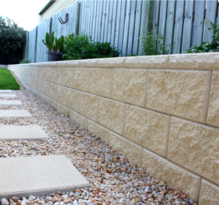 3_blocks_high_Ivory_vertical_faced_retaining_wall_with_a_pebbled_footpath_with_large_format_Ivory_pavers_used_as_stepping_stones