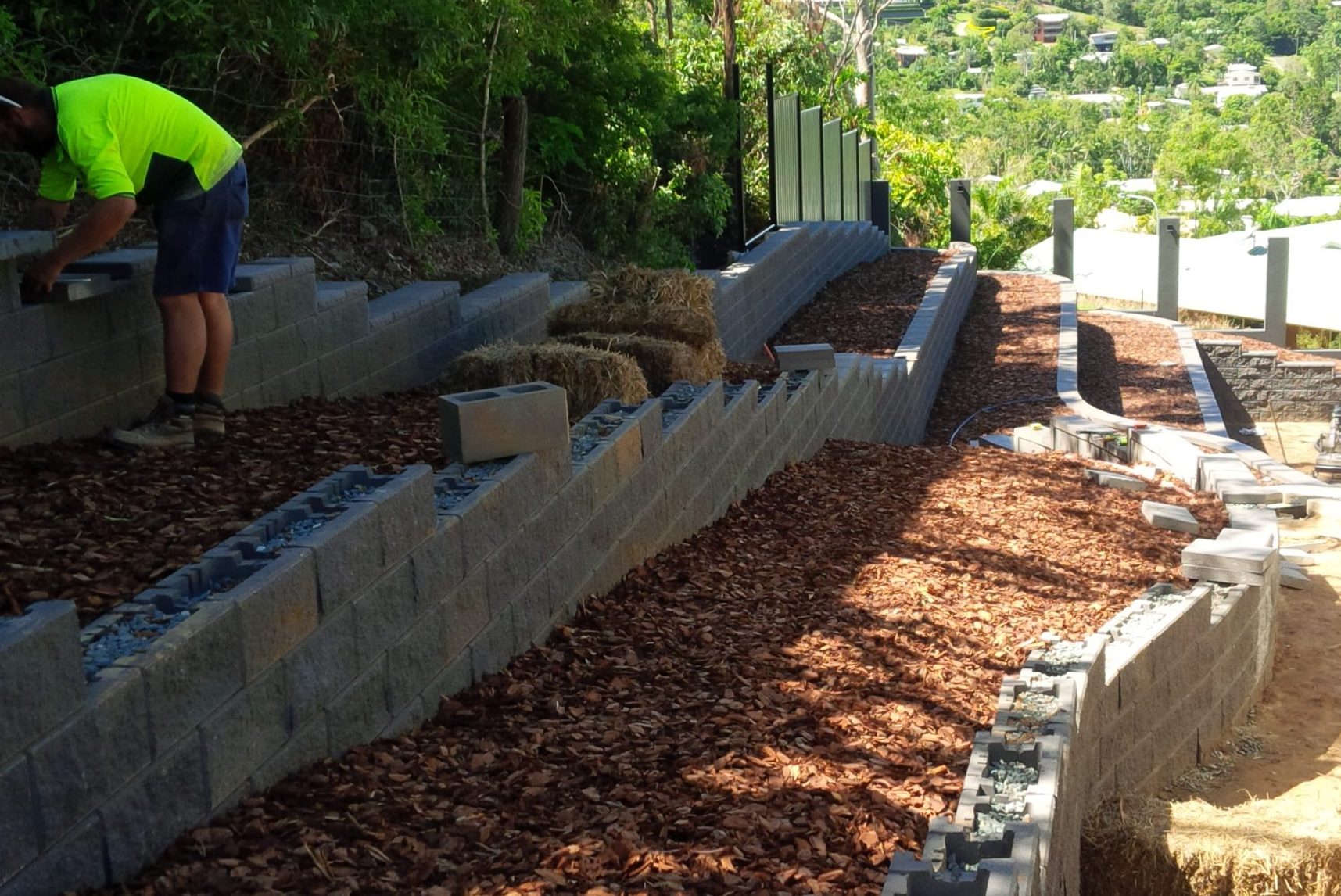 Professional_landscapers_creating_large_retaining_walls_with_green_location_pins_to_keep_the_walls_in_stretcher_bond